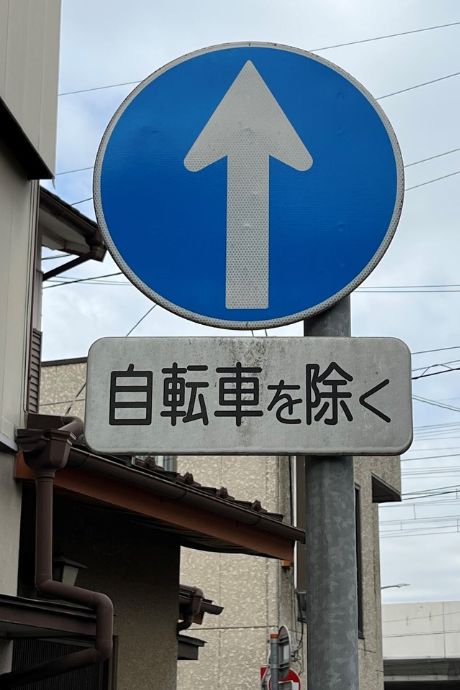 No Turn Sign - The Japanese characters on the white sign below show bicycles are exempt