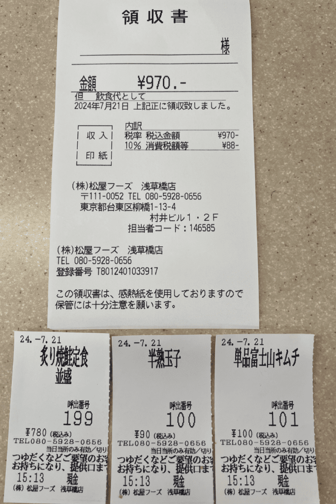 This image displays a receipt from a Matsuya restaurant in Japan, showing a total amount of ¥970 for the meal. The detailed breakdown includes items such as a grilled meal set, a soft-boiled egg, and a serving of kimchi, each with individual prices and order numbers (199, 100, and 101 respectively). The receipt also includes tax information, the restaurant's contact details, and the date of purchase, July 21, 2024. Below the main receipt are three smaller order tickets, corresponding to the individual items ordered.