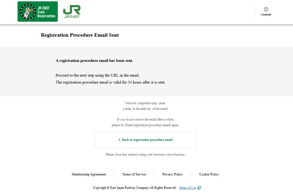 JR-East Train Reservation confirmation page indicating that a registration procedure email has been sent. Instructions advise users to proceed using the URL in the email, valid for 24 hours. A message highlights potential delays due to network congestion and includes a 'Back to registration procedure email' button. Footer links to Membership Agreement, Terms of Service, Privacy Policy, and Cookie Policy.