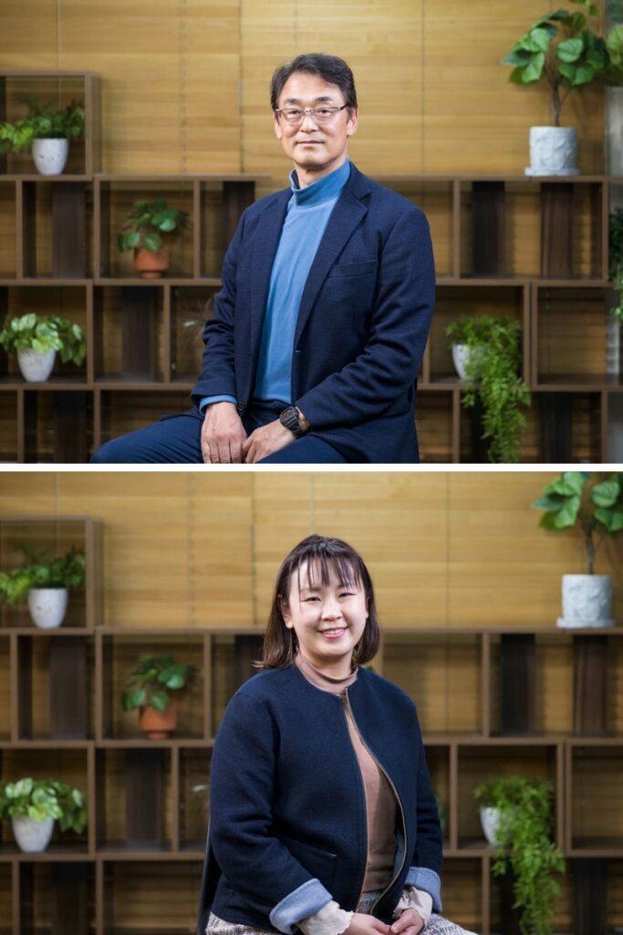 A professional composite image shows two individuals seated separately against the same background of wooden paneling and neatly arranged potted plants on open shelves. The upper image features a man in a dark blazer and light blue turtleneck, wearing glasses and smiling gently at the camera. The lower image features a woman in a dark jacket with a beige top, smiling warmly. The setting conveys a welcoming and professional atmosphere.