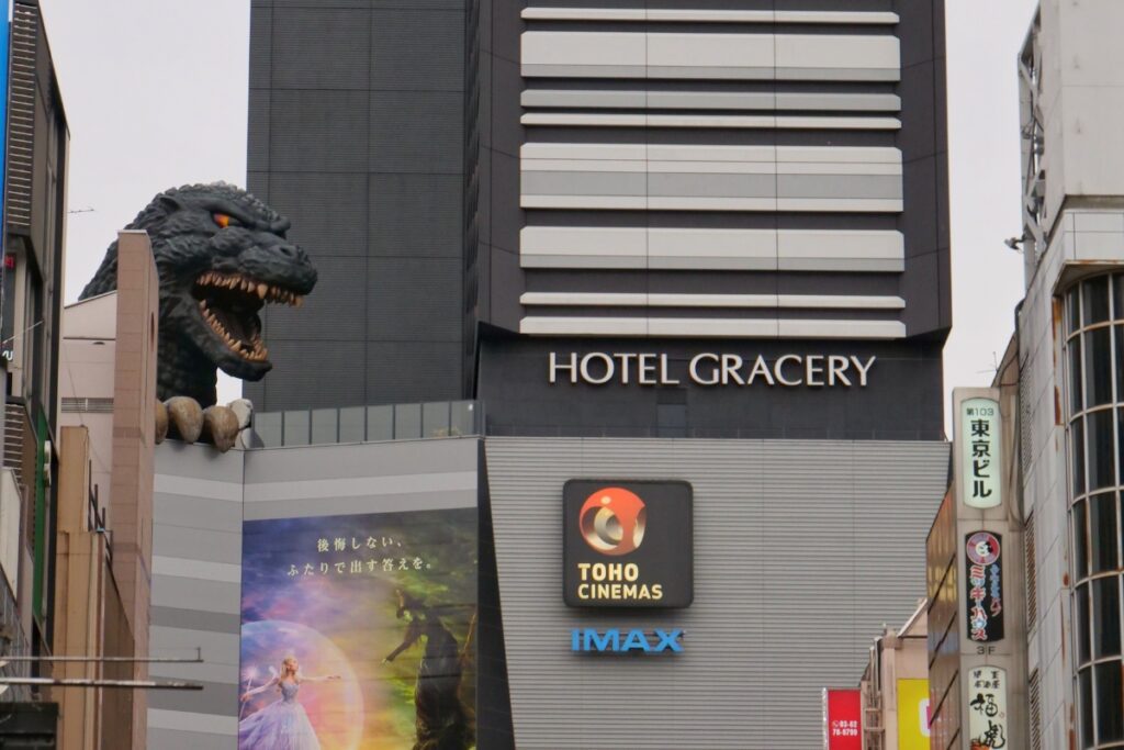 Hotel Gracery Shinjuku exterior with the rooftop Godzilla statue and Toho Cinemas IMAX signage below.